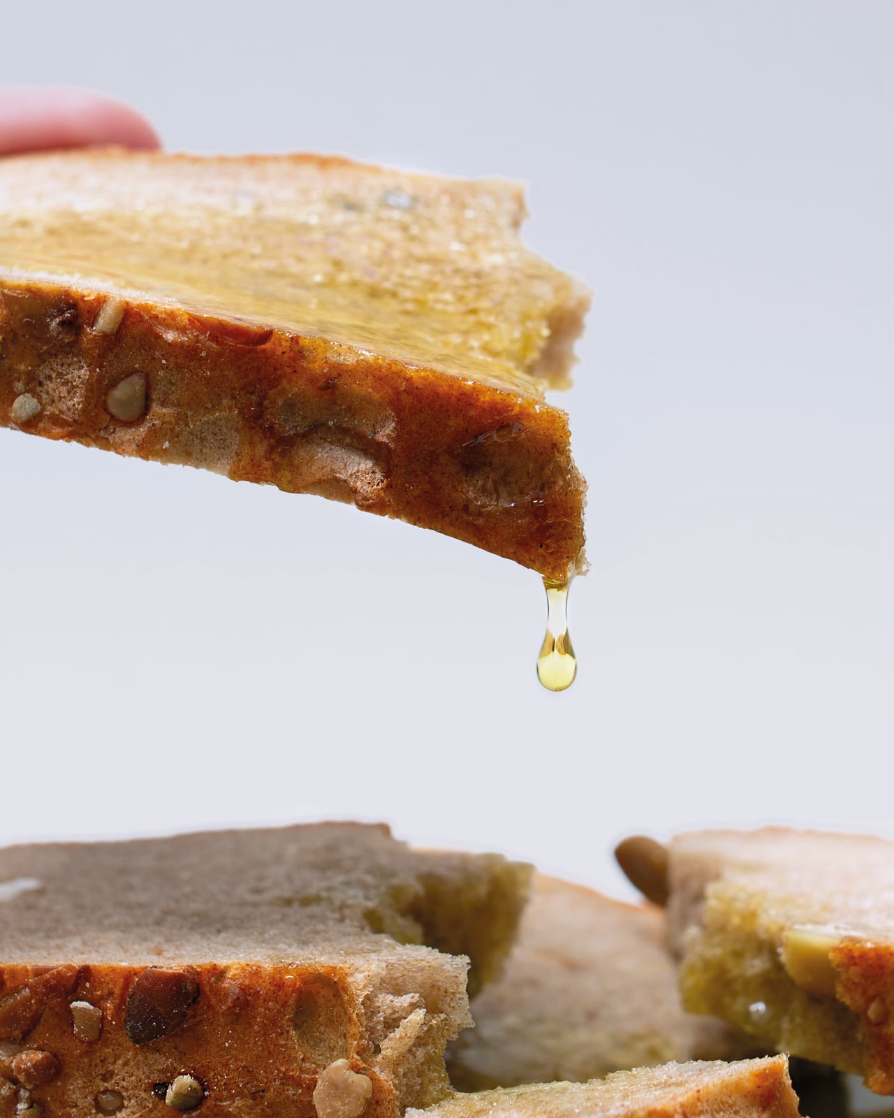 Aceitunas verdes en un plato con aceite cayendo de una cuchara